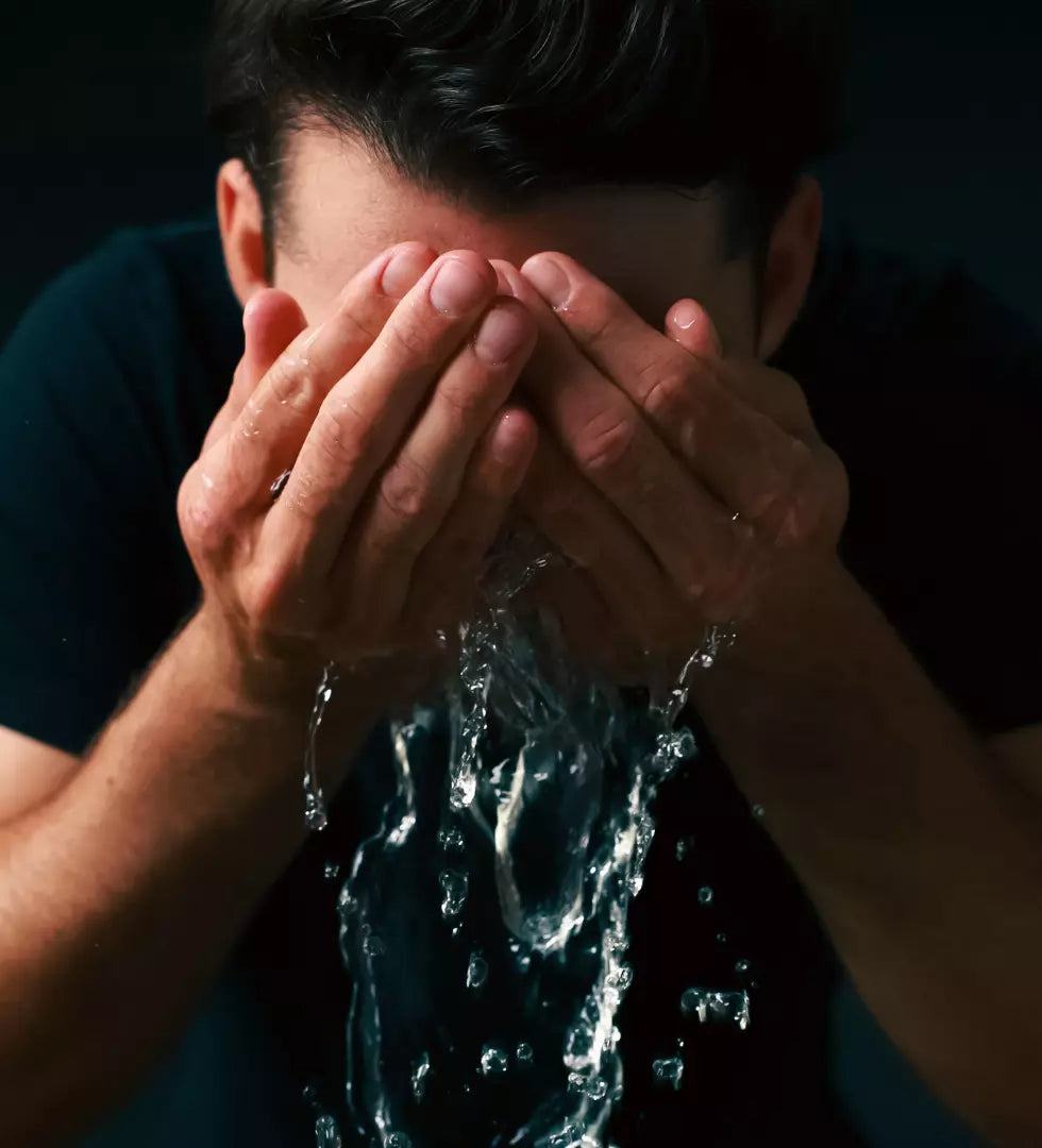 Mann reinigt sein Gesicht mit natürlichem Gesichtswaschmittel für Männerpflege